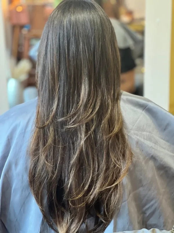 cabello muestra un balayage en cabellos castaños claro sutil y natural, ademas un corte en capas que ayudan a dar naturalidad al trabajo realizado en la peluquería en Concón