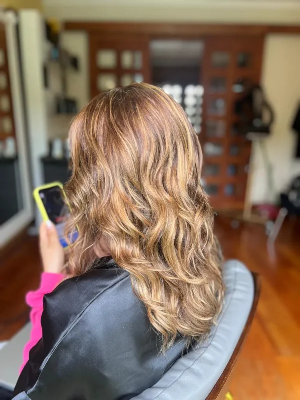 Mujer de lado luce un Balayaga en color Castaño realizado en Peluquería en Concón